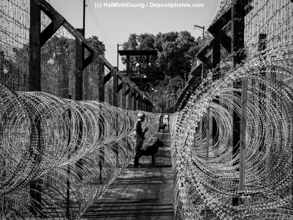 Stacheldrahtzäune an Gefängnis werden von Wachhund gesichert