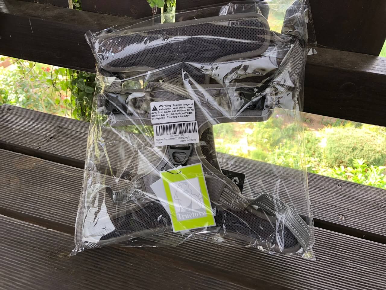 In einer Plastiktüte verpacktes Hundegeschirr. Beschriftung lautet: Das Geschirr kam gut verpackt bei uns an.