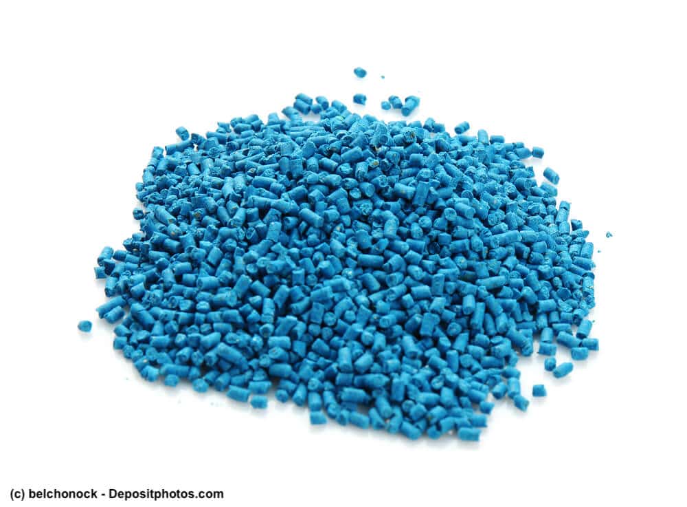 Haufen blauer Pellets von Schneckenkorn auf weißem Hintergrund